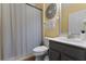 Bathroom with gray vanity, decorative mirror, and walk-in shower with neutral colored shower curtain at 13431 Early Frost Cir, Orlando, FL 32828