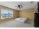 This bedroom has a ceiling fan, tan walls, and a large window for natural light at 13431 Early Frost Cir, Orlando, FL 32828
