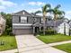 Well-maintained home with a two-car garage, green lawn, and vibrant palm trees at 13431 Early Frost Cir, Orlando, FL 32828