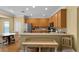 Well-lit kitchen featuring wood cabinetry, a stainless steel refrigerator, and dining area at 13431 Early Frost Cir, Orlando, FL 32828