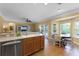 Open-concept kitchen with stainless steel dishwasher flowing into the breakfast nook and living area at 13431 Early Frost Cir, Orlando, FL 32828