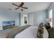 Cozy main bedroom with a ceiling fan, a TV, and a view into the bathroom at 13431 Early Frost Cir, Orlando, FL 32828