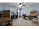 This home office features natural light, multiple desks and a ceiling fan at 13431 Early Frost Cir, Orlando, FL 32828