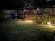 Well maintained backyard at night with grass and garden beds at 1420 Knollwood St, Orlando, FL 32804