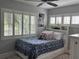 Cozy bedroom with a blue patterned comforter, a ceiling fan, and large windows at 1420 Knollwood St, Orlando, FL 32804