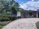 Charming brick home featuring a brick driveway, manicured landscaping, and a welcoming front porch with seating at 1420 Knollwood St, Orlando, FL 32804