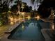 Evening view of the pool illuminated by landscape lighting and surrounded by lush greenery at 1420 Knollwood St, Orlando, FL 32804
