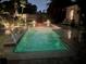 Outdoor pool at night with bright lighting and beautiful landscaping around the area at 1420 Knollwood St, Orlando, FL 32804