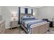 Bedroom with a bed with blue and white bedding and neutral walls at 15577 Willow Arbor Cir, Orlando, FL 32824