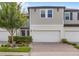 Inviting two-story townhome featuring a two-car garage, brick paved driveway, and lush landscaping at 15577 Willow Arbor Cir, Orlando, FL 32824