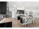 Open kitchen featuring dark cabinetry, stainless steel appliances, and a large island with bar stools at 15577 Willow Arbor Cir, Orlando, FL 32824