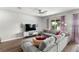 Cozy living room featuring a large gray sectional, modern decor, and natural light at 15577 Willow Arbor Cir, Orlando, FL 32824