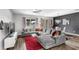 Modern living room with gray sectional sofa, wood floors, and chandelier at 15577 Willow Arbor Cir, Orlando, FL 32824