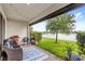 Relaxing outdoor patio with comfortable seating, a grill, and a scenic view of the lake at 15577 Willow Arbor Cir, Orlando, FL 32824