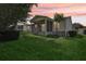 Backyard and screened-in patio set against a gorgeous sunset at 17097 Se 96Th Chapelwood Cir, The Villages, FL 32162