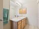 Bright bathroom featuring a sink with cabinet storage and a large mirror with vanity lighting at 17097 Se 96Th Chapelwood Cir, The Villages, FL 32162