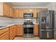 Kitchen featuring stainless steel appliances, light wood cabinets, and plenty of counter space at 17097 Se 96Th Chapelwood Cir, The Villages, FL 32162