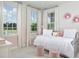 Charming bedroom features soft pink accents, ample natural light, and cozy furniture, creating a serene retreat at 1969 Beach Ter, Celebration, FL 34747