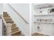 Bright staircase featuring light wood stairs, white walls, and built-in shelving with stylish decor accents at 1969 Beach Ter, Celebration, FL 34747