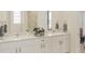 Bright bathroom featuring a double vanity with white cabinetry, a large mirror, and stylish decor at 1993 Beach Ter, Celebration, FL 34747