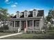 Charming cottage-style home featuring a welcoming front porch and three dormer windows, complemented by lush landscaping at 1993 Beach Ter, Celebration, FL 34747