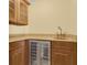 Wet bar featuring granite countertops, wine cooler, custom cabinetry, and a copper sink at 202 Riverview Dr, Longwood, FL 32779