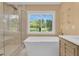 Bright bathroom with tub, a large window, and a glass enclosed shower at 202 Riverview Dr, Longwood, FL 32779