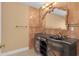 Ornate bathroom with tiled walls, vanity, and gold fixtures at 202 Riverview Dr, Longwood, FL 32779
