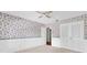 Bright bedroom featuring patterned wallpaper, closet and ceiling fan at 202 Riverview Dr, Longwood, FL 32779