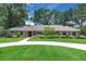 Beautiful single-story brick home featuring a long driveway, lush landscaping, and mature trees at 202 Riverview Dr, Longwood, FL 32779