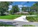 Charming single-story brick home with a circular driveway, large front lawn, and mature trees at 202 Riverview Dr, Longwood, FL 32779