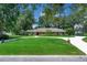 Inviting single-story home with brick exterior, manicured lawn, circular driveway, and mature landscaping at 202 Riverview Dr, Longwood, FL 32779