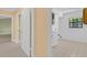 Hallway leading to a laundry room and bedroom with light tile floors at 202 Riverview Dr, Longwood, FL 32779