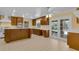 Charming kitchen with wood cabinets, tile flooring, and access to the pool area through glass doors at 202 Riverview Dr, Longwood, FL 32779