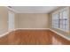 A spacious living room featuring hardwood floors and natural light from the large window with plantation shutters at 202 Riverview Dr, Longwood, FL 32779