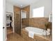 Elegant bathroom featuring a soaking tub, walk-in shower, and an organized walk-in closet space at 20796 Quinn St, Orlando, FL 32833