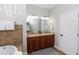 Spacious bathroom showcasing double sink vanity, large mirror, and tub, all complemented by neutral tile at 20796 Quinn St, Orlando, FL 32833