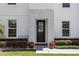 Elegant home entrance with decorative wreath, stone accents, and lush landscaping at 20796 Quinn St, Orlando, FL 32833