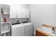 Bright laundry room equipped with modern washer/dryer units, cabinet storage and a utility sink at 20796 Quinn St, Orlando, FL 32833