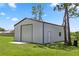 Spacious metal outbuilding with a roll-up door and a side entrance on a grassy lot at 20796 Quinn St, Orlando, FL 32833