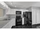Galley kitchen featuring modern black appliances, sleek countertops, and white cabinetry at 2206 Stonington Ave # 2206, Orlando, FL 32817
