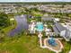 Beautiful aerial view of a resort-style community pool, playground, and pristine lake with fountain at 2247 Marsh Sedge Ln, Winter Park, FL 32792
