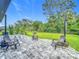 Beautiful backyard featuring a paver patio, chairs, swing, lush lawn, and privacy fencing at 2247 Marsh Sedge Ln, Winter Park, FL 32792