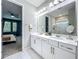 Well-lit bathroom with a double vanity, modern fixtures, and a view into the Primary bedroom at 2247 Marsh Sedge Ln, Winter Park, FL 32792