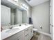 Clean bathroom features a double sink vanity, large mirror, and a shower with white tiling at 2247 Marsh Sedge Ln, Winter Park, FL 32792