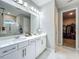 Elegant bathroom with double vanity, white cabinets, a large mirror, and a walk-in closet at 2247 Marsh Sedge Ln, Winter Park, FL 32792