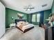 Spacious bedroom showcasing a king-size bed, stylish green walls, and a cozy reading nook at 2247 Marsh Sedge Ln, Winter Park, FL 32792