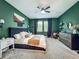 Charming bedroom with a king-size bed, elegant green walls, and ample natural light from the windows at 2247 Marsh Sedge Ln, Winter Park, FL 32792