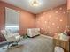 Cozy Bedroom featuring a white crib, rocking chair, and a delightful floral wall decor at 2247 Marsh Sedge Ln, Winter Park, FL 32792