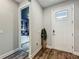 Entryway featuring stylish wood floors, a white door, and an inviting view into a bedroom at 2247 Marsh Sedge Ln, Winter Park, FL 32792